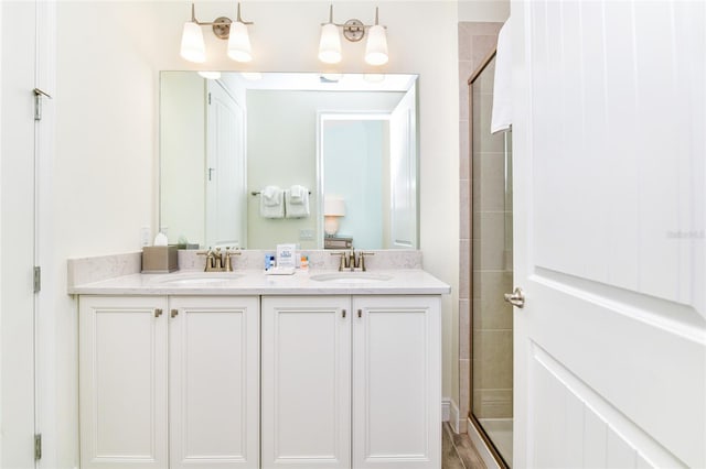 bathroom featuring vanity, wood-type flooring, and a shower with door