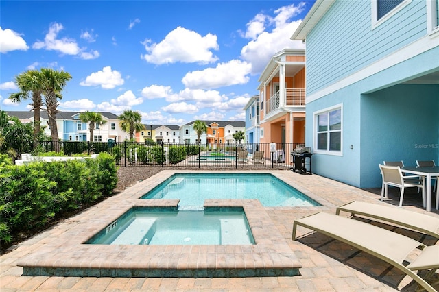 view of pool with a patio, an in ground hot tub, and grilling area