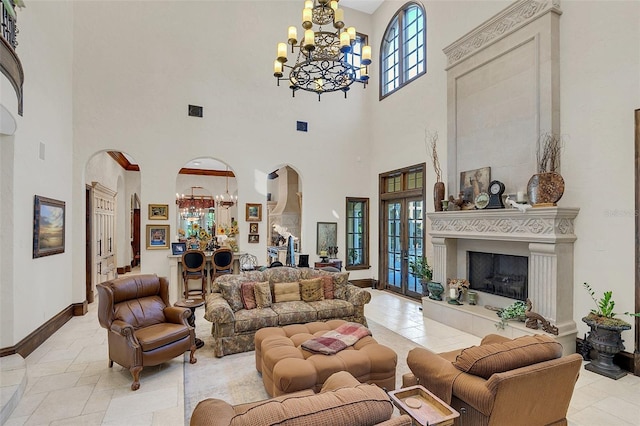 living room featuring a chandelier, a high ceiling, and a tiled fireplace