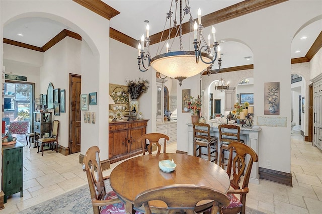 dining area featuring crown molding, a towering ceiling, and a notable chandelier