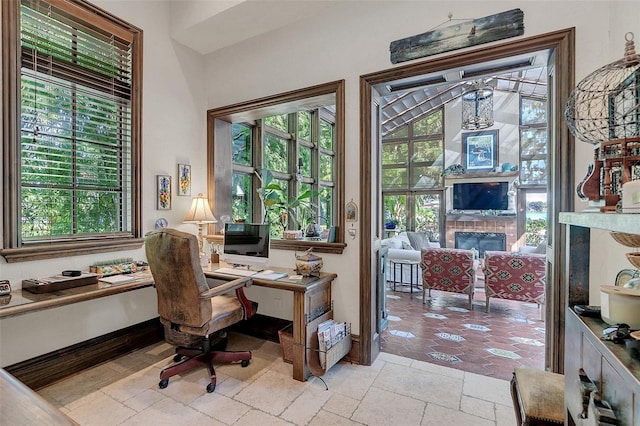 office area with a healthy amount of sunlight and a tiled fireplace