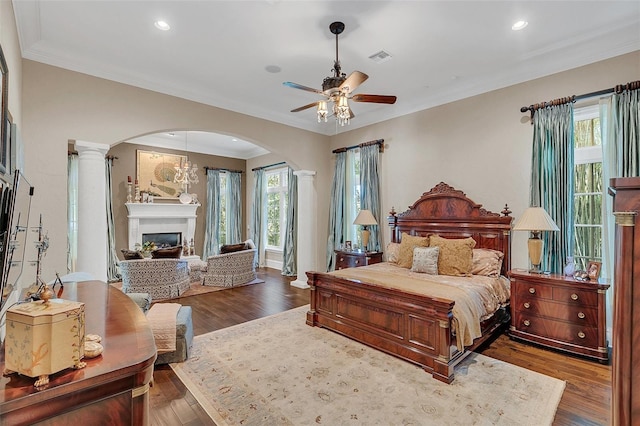 bedroom with ceiling fan, dark hardwood / wood-style flooring, and ornate columns