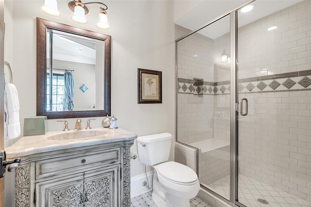 bathroom with tile patterned floors, vanity, a shower with shower door, and toilet