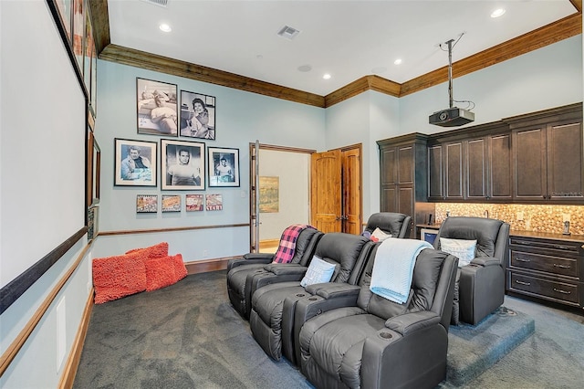 home theater featuring dark colored carpet, a high ceiling, and crown molding