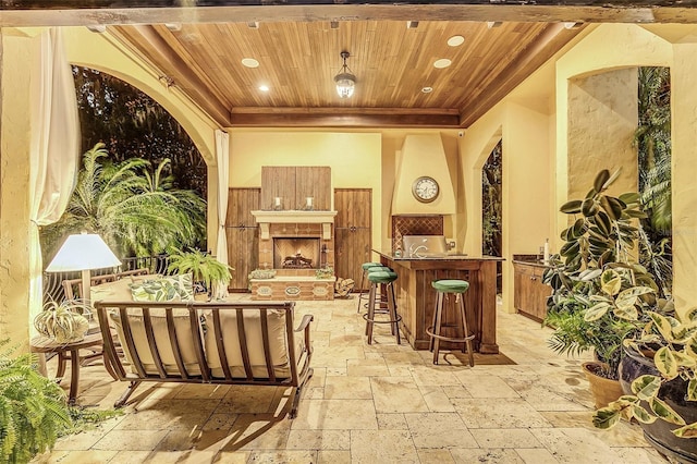 view of patio with an outdoor living space with a fireplace and exterior bar