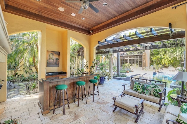 view of patio with ceiling fan, an outdoor bar, and a pergola