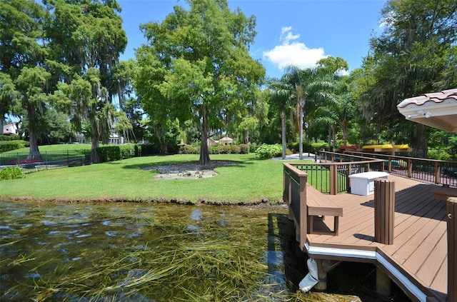 dock area with a deck with water view and a lawn