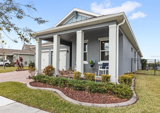 view of front of home with a front yard, a porch, and a garage