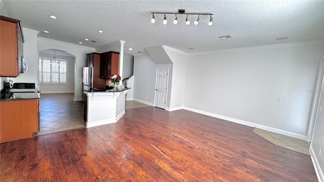 kitchen featuring stove, a textured ceiling, rail lighting, and ornamental molding