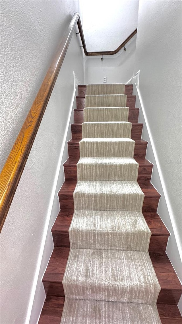 stairs featuring hardwood / wood-style floors