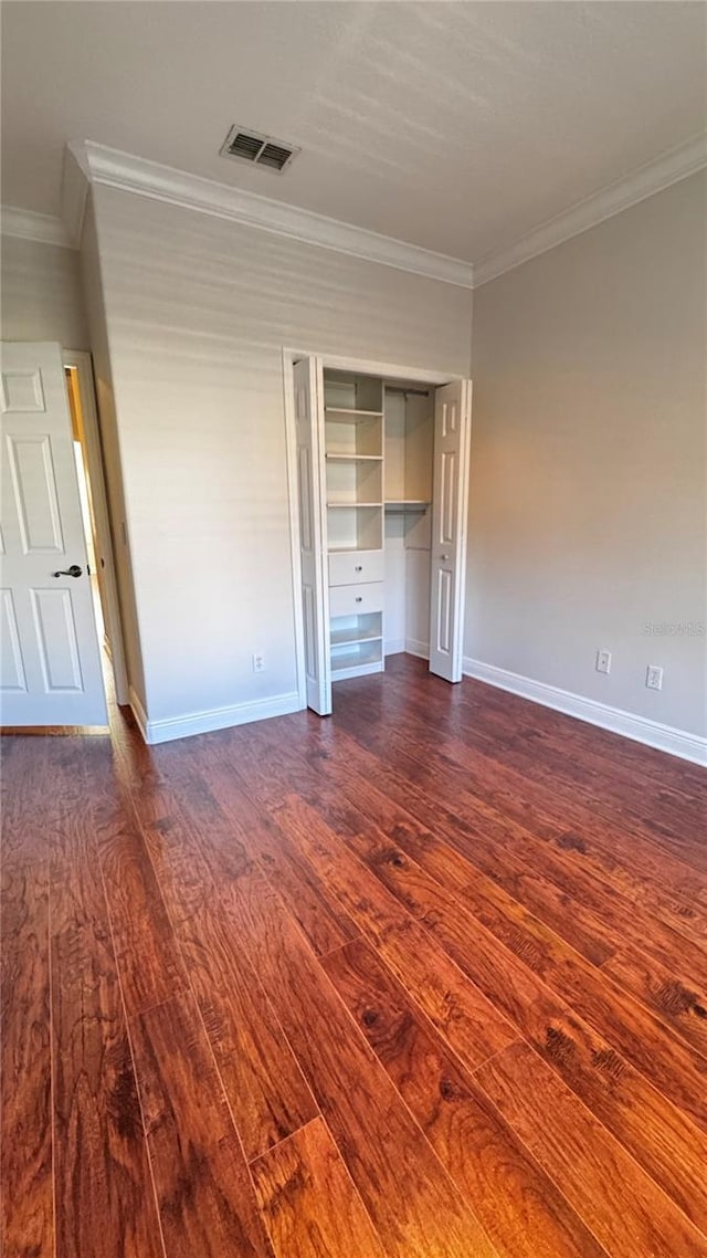 unfurnished bedroom featuring dark hardwood / wood-style flooring, a closet, and ornamental molding