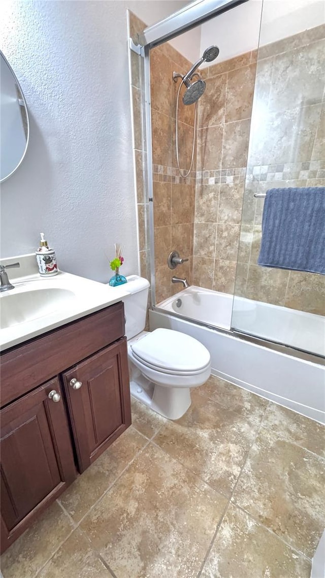 full bathroom featuring vanity, toilet, and bath / shower combo with glass door