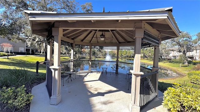 view of patio with a gazebo, ceiling fan, and a water view