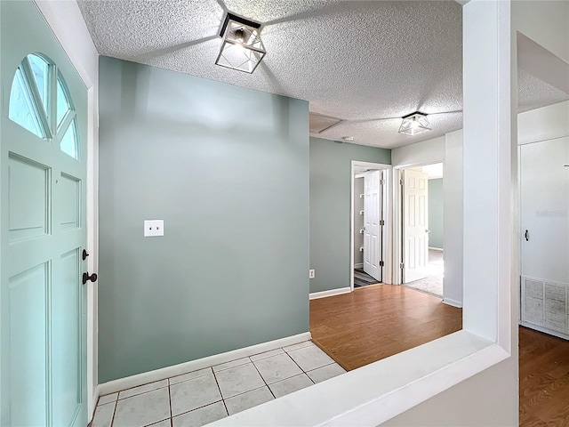 foyer with light tile patterned floors and a textured ceiling