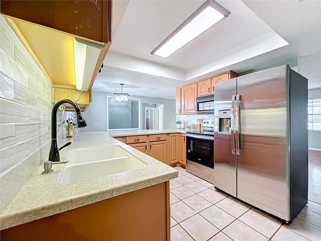 kitchen featuring sink, kitchen peninsula, decorative backsplash, light tile patterned floors, and appliances with stainless steel finishes