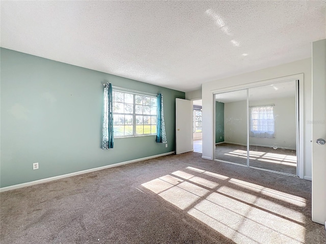 unfurnished bedroom featuring carpet, a textured ceiling, and a closet