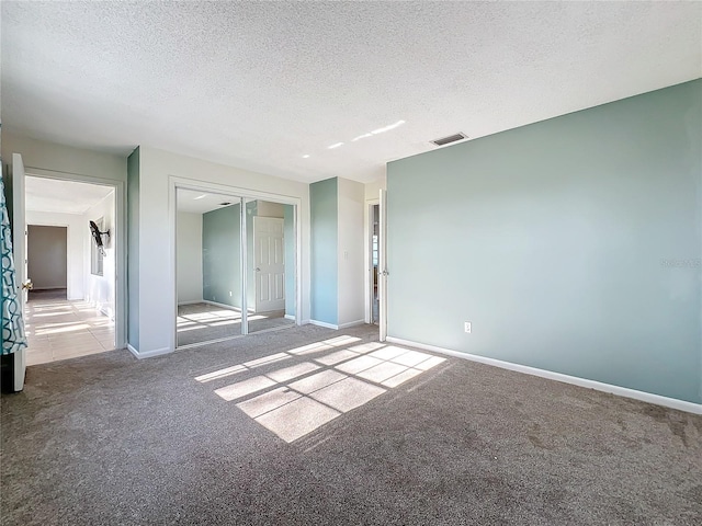 carpeted spare room with a textured ceiling