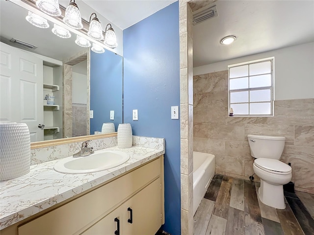 bathroom featuring wood-type flooring, vanity, toilet, and tile walls