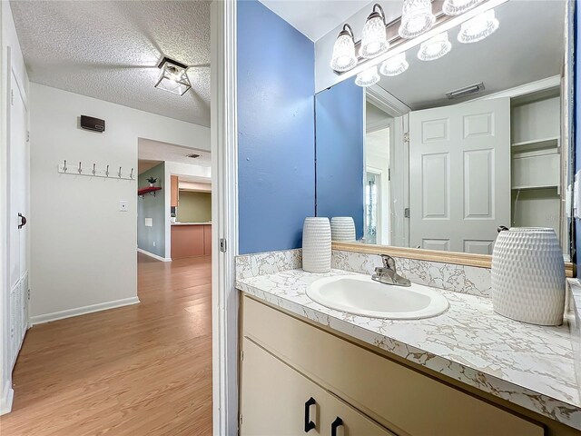 bathroom featuring vanity, a textured ceiling, and hardwood / wood-style flooring