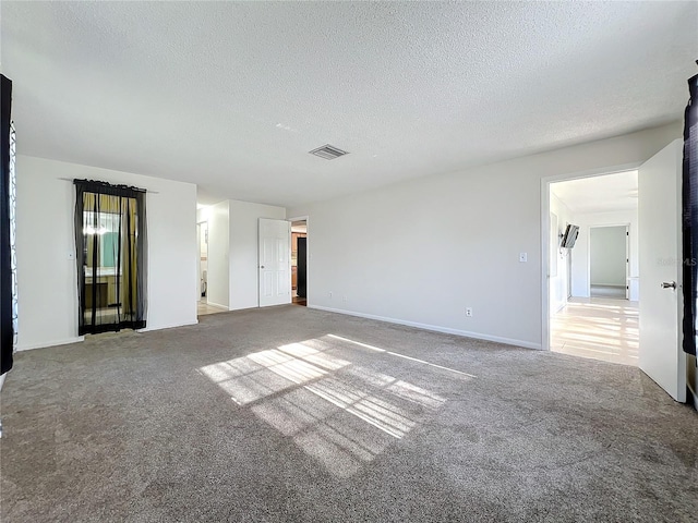 carpeted spare room featuring a textured ceiling