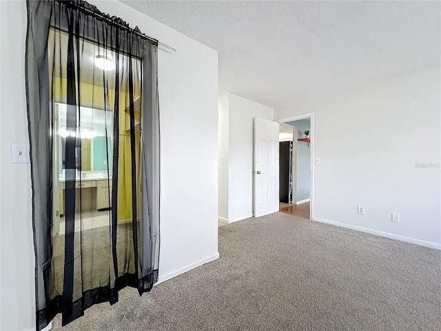 carpeted empty room featuring a textured ceiling