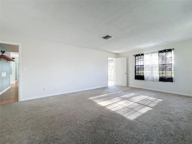 carpeted empty room with a textured ceiling