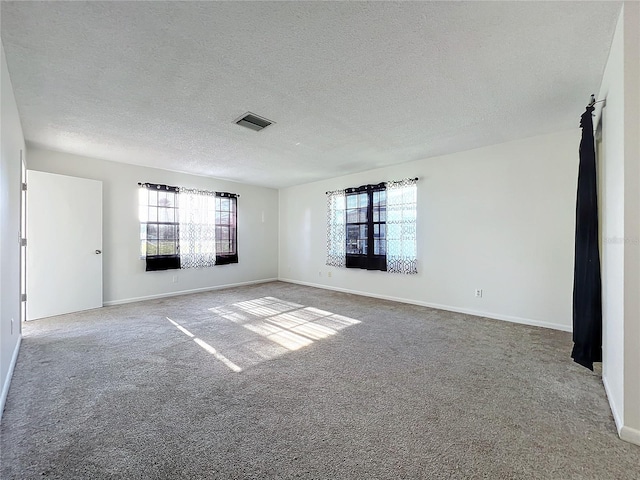 carpeted empty room with a textured ceiling