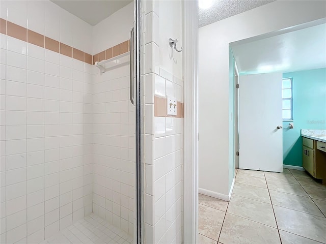 bathroom featuring a shower with door, vanity, a textured ceiling, and tile patterned flooring