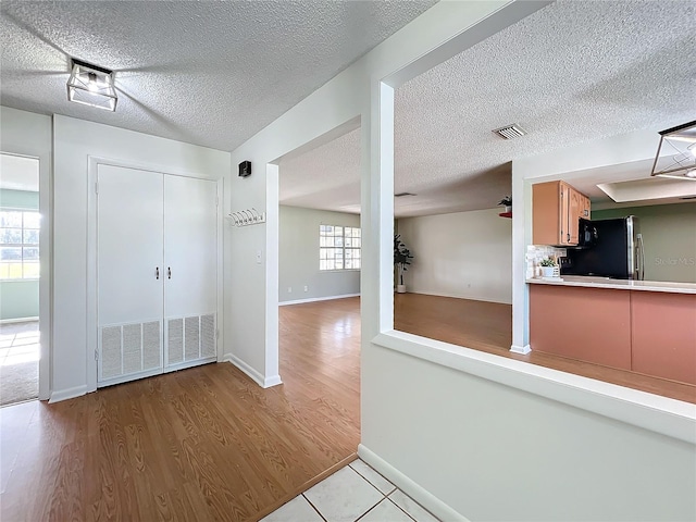 interior space featuring light hardwood / wood-style floors and a textured ceiling