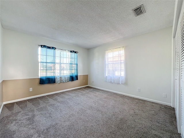 spare room with carpet flooring and a textured ceiling