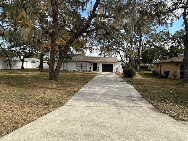 ranch-style house featuring a front yard and a garage