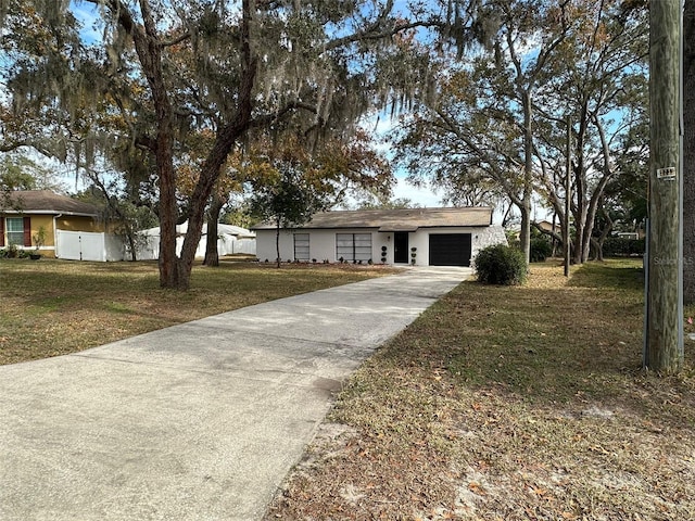 ranch-style home with a garage and a front lawn