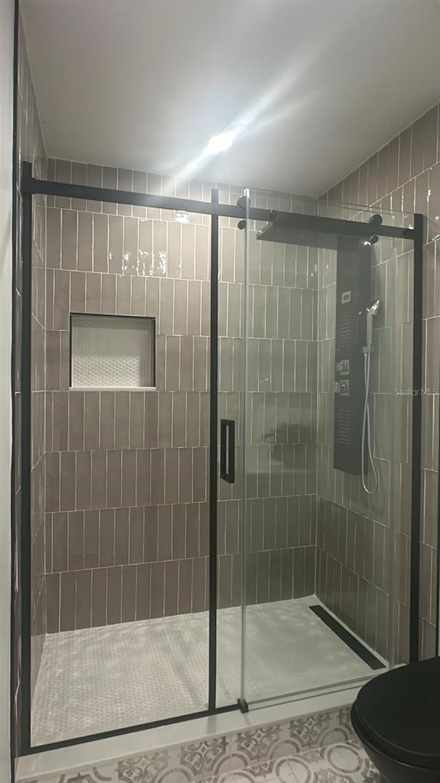 bathroom featuring toilet and an enclosed shower