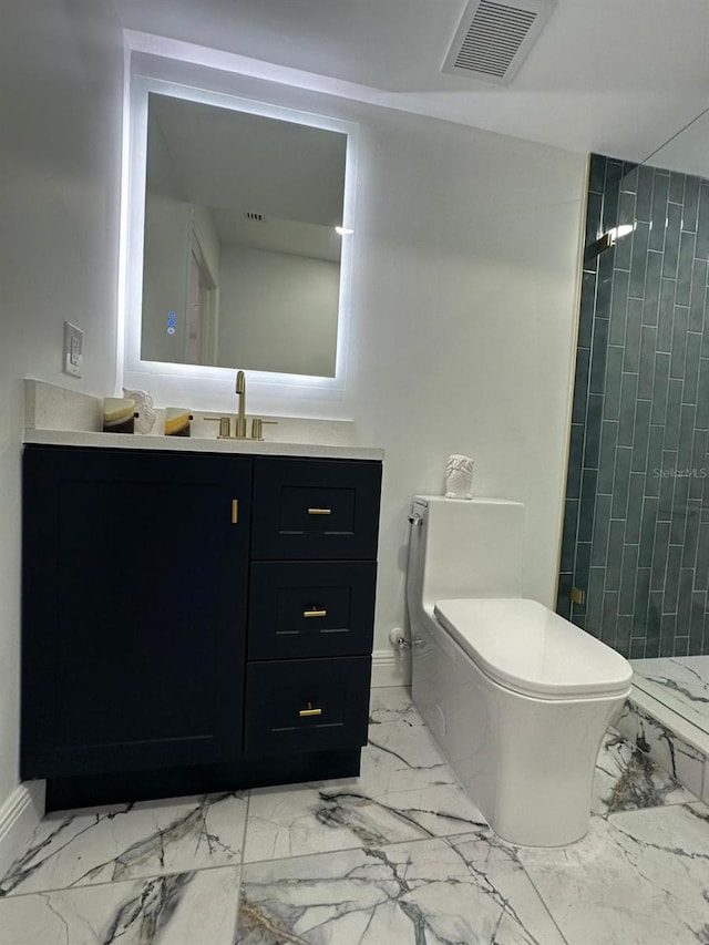 bathroom with tiled shower, vanity, and toilet