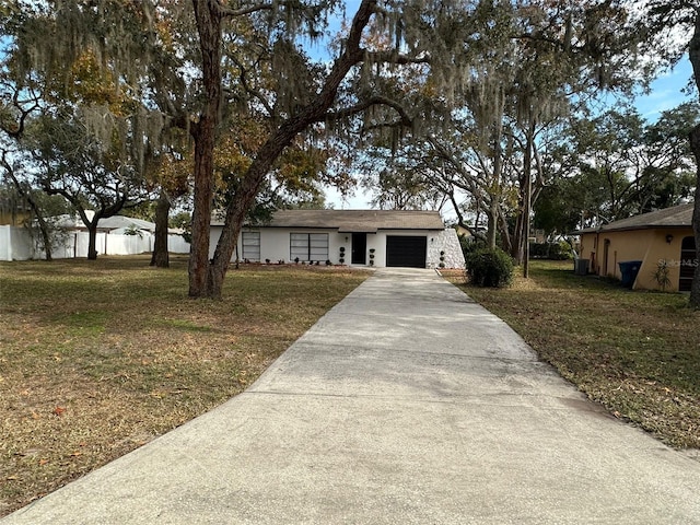 ranch-style house with a garage and a front lawn