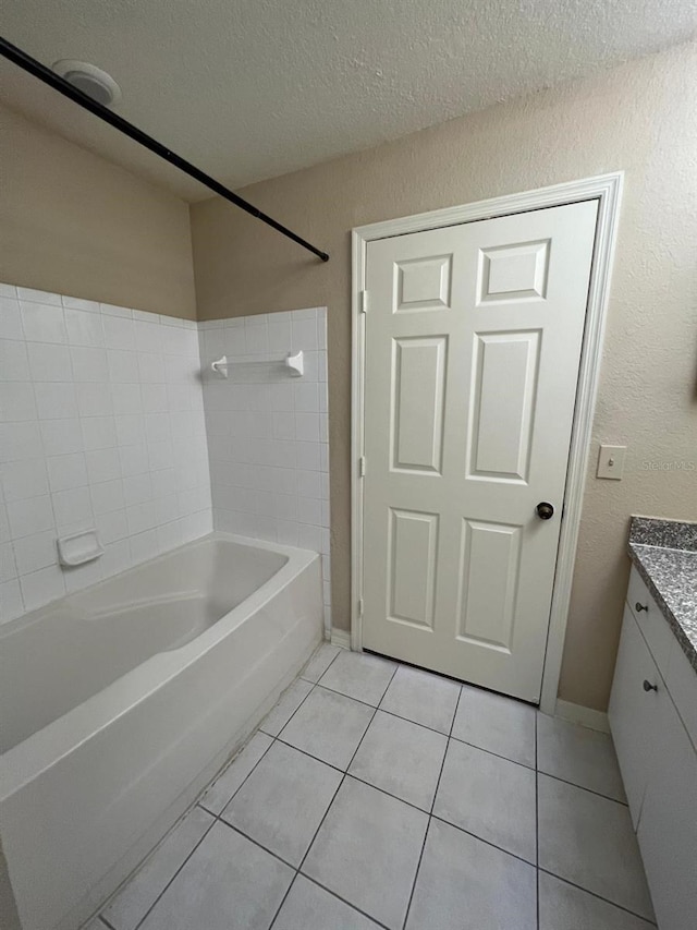 bathroom with tile patterned floors, vanity, a textured ceiling, and tub / shower combination