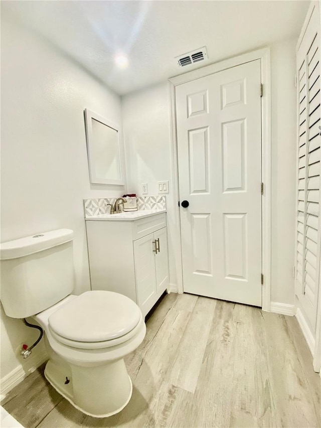 bathroom featuring vanity, hardwood / wood-style flooring, and toilet