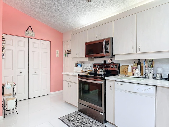 kitchen with stainless steel appliances, vaulted ceiling, and a textured ceiling