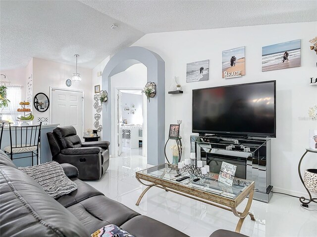 living room with vaulted ceiling and a textured ceiling