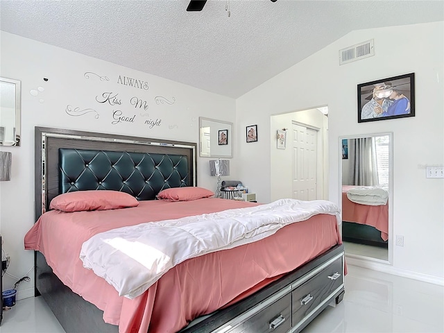 bedroom with vaulted ceiling, ceiling fan, and a textured ceiling