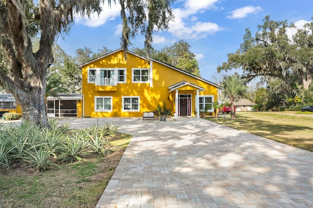 view of front of home with a front lawn and a sunroom