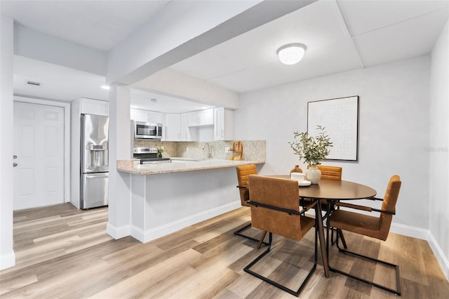 dining room featuring sink and light hardwood / wood-style floors