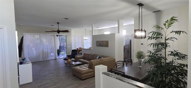 living room featuring dark hardwood / wood-style floors and ceiling fan with notable chandelier