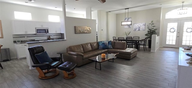 living room featuring a high ceiling, light wood-type flooring, and french doors