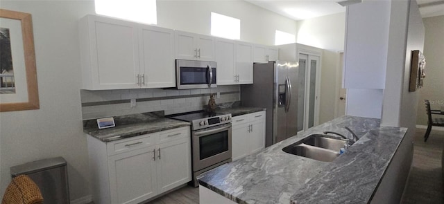 kitchen with white cabinetry, sink, decorative backsplash, and stainless steel appliances