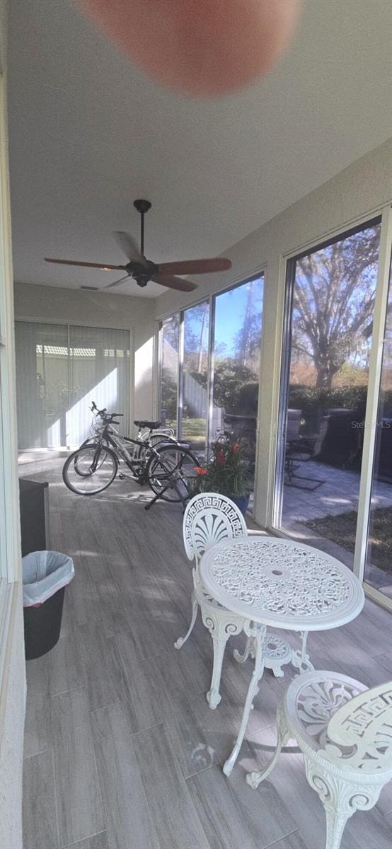 sunroom / solarium featuring ceiling fan