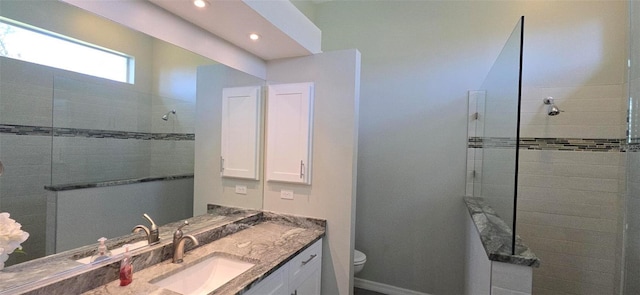 bathroom featuring vanity, toilet, and tiled shower