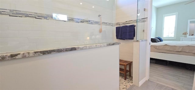 bathroom featuring tile patterned flooring and tiled shower