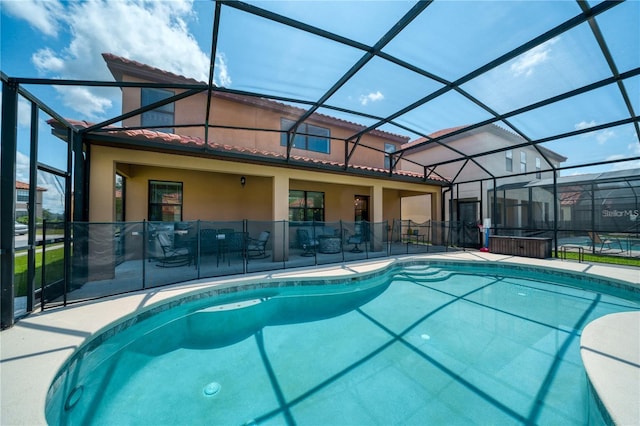 view of swimming pool with glass enclosure and a patio