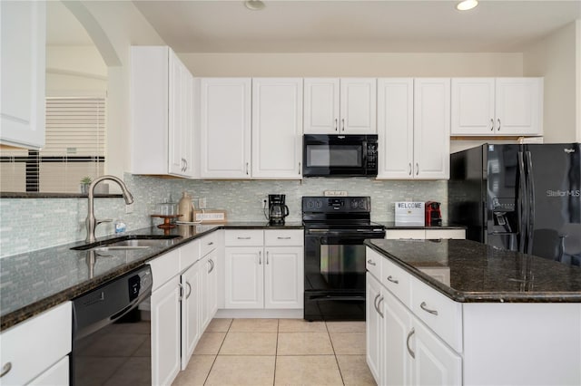 kitchen featuring black appliances, dark stone countertops, white cabinets, and sink